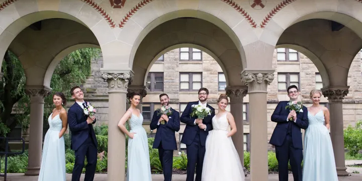 Wedding party posing under outdoor arches at The Hotel at Oberlin