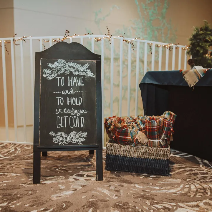 Basket of blankets with a sign for wedding guests