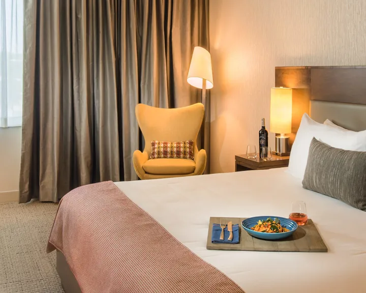Hotel room with room service tray on a king bed
