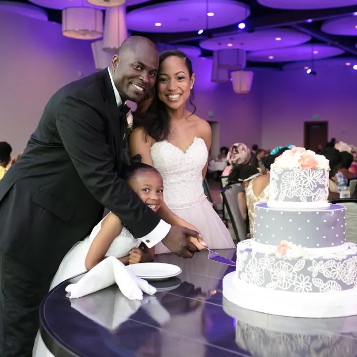 A newly married couple cutting their wedding cake